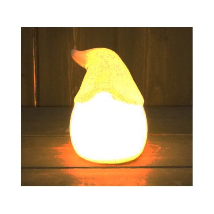 A small ceramic gonk head with only grey and white tones, complete with a warm glowing LED central light 