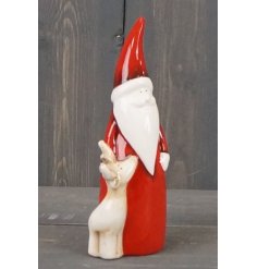 A charming and simple ornamental Santa figure with a little reindeer feature and sleek red toned look 