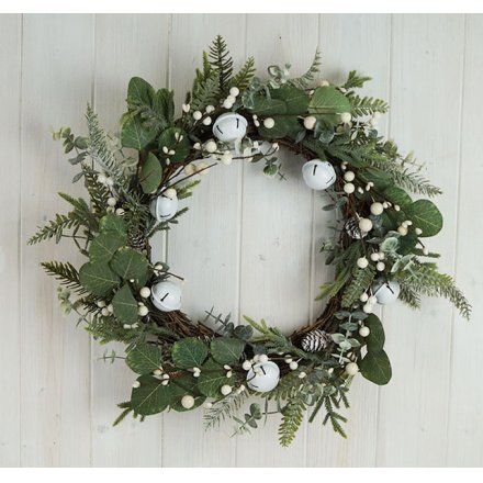 A large artificial wreath featuring charming green foliage and added white jingle bells and berries 