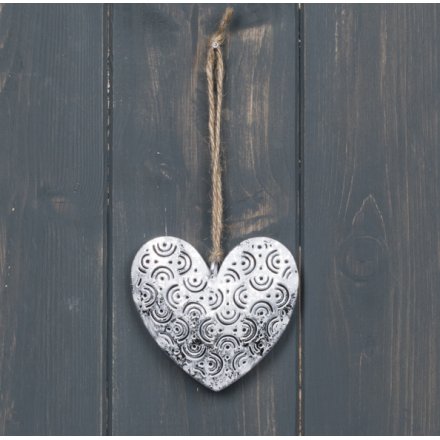 A simple accent to bring to any home space, a hanging metal heart with a patterned decal and jute string 