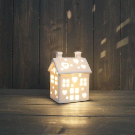 A small ceramic house with an LED glow from its centre
