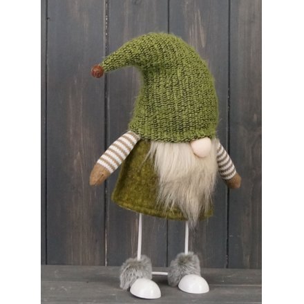 A brown and green toned fabric gonk figure with free standing legs and faux fur trims 