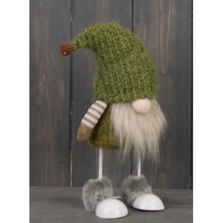 A brown and green toned fabric gonk figure with free standing legs and faux fur trims 
