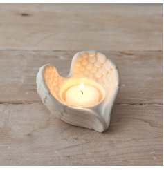 A charming and simple angel wing shaped tlight holder with a sleek white glaze tone to complete the look 