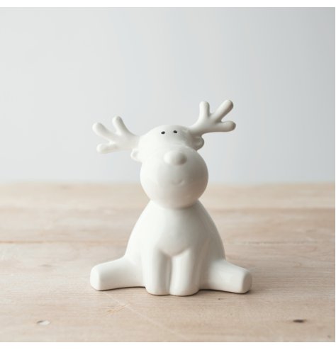 A fun and festive themed sitting ceramic reindeer figure, perfectly posed with a subtle smile and minimalistic detailing