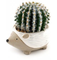 An adorable little hedgehog inspired pot with neutral two tones and an artificial cactus potted inside 