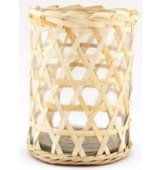 A clear glass vase set within a simplistic inspired woven rattan casing 