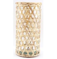 A clear glass vase set within a simplistic inspired woven rattan casing 
