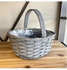 A charmingly simple woven wooden trug in a grey tone, complete with a matching handle and plastic inner lining 