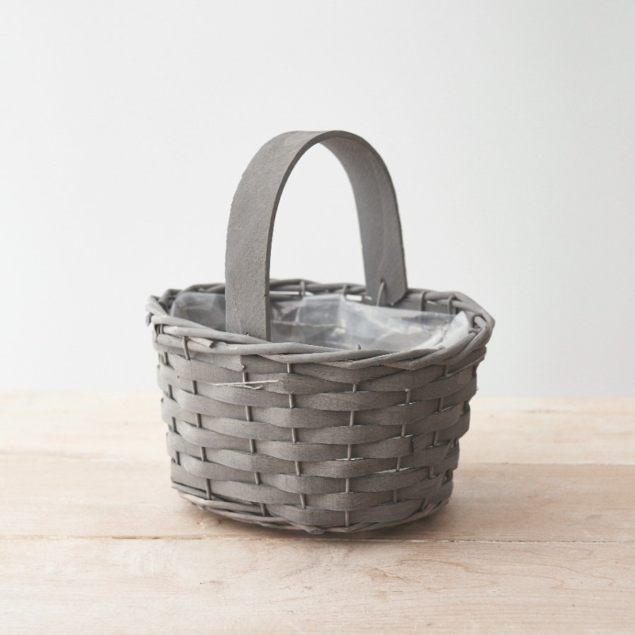 A charmingly simple woven wooden trug in a grey tone, complete with a matching handle and plastic inner lining 