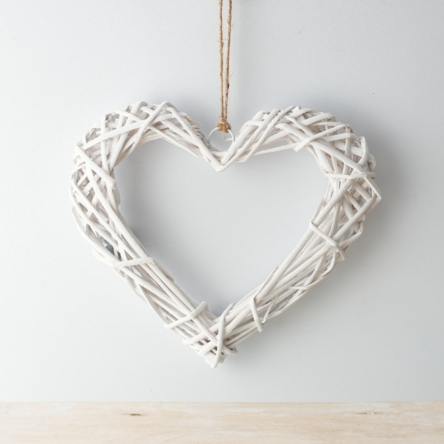 A chic white woven wicker heart with a jute string for hanging 