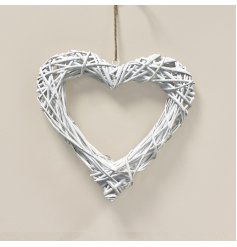A woven wicker wreath in a heart shape, complete with a white washed finish and jute string for hanging