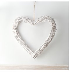 A chic white woven wicker heart with a jute string for hanging 