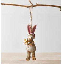 A charming little hanging bunny dressed with a Santa hat and star