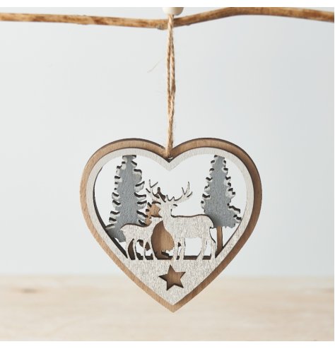 A hanging wooden heart with a layered woodland scene display in its centre 