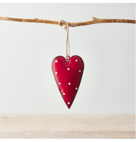 A hanging metal heart covered with a soft red tone, distressed edge finish and added white dotty print 
