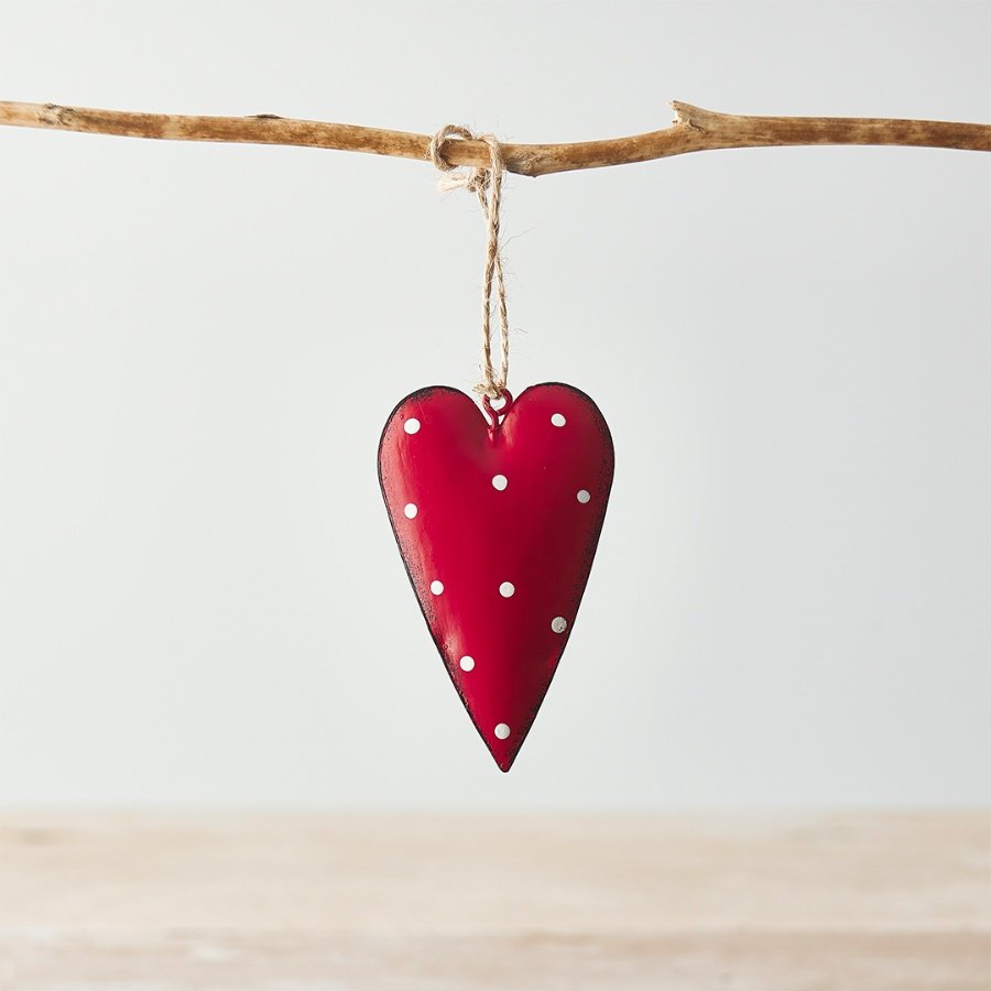 A red toned metal hanging heart with an overly distressed design and added white polka dot print to finish 