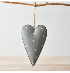 A grey toned metal hanging heart with an overly distressed design and added white polka dot print to finish 