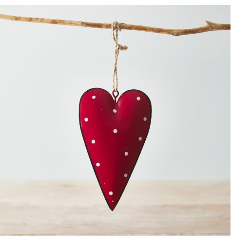 A hanging metal heart covered with a soft red tone, distressed edge finish and added white dotty print 