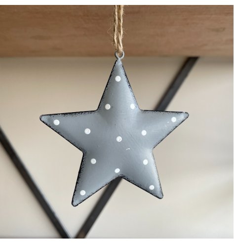 A hanging metal star covered with a soft grey tone, distressed edge finish and added white dotty print 
