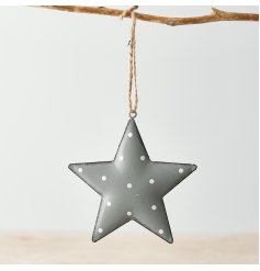 A grey toned metal hanging star with an overly distressed design and added white polka dot print to finish 