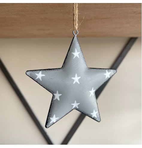 A hanging metal star covered with a soft grey tone, distressed edge finish and added white starry print 