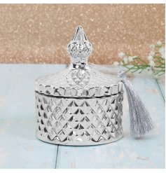 a sleek silver toned diamond ridge candle holder complete with vintage accents and a fuzzy tassel 