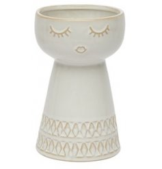 A delicately decorated vase featuring a feminine face with an intricate pattern. 