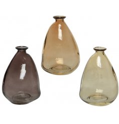 An assortment of 3 beautifully coloured glass vases. Each has a sculptural aesthetic and is in a neutral colour.