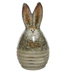 A rustic glazed bunny egg with pointed ears and a cute smiling face. A unique item with a distressed finish
