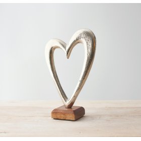 A Large Metal Heart Ornament on a Wooden Block