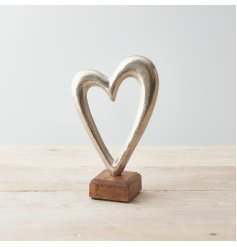 A simplistic Metal Heart in Silver, set on a Wooden Base