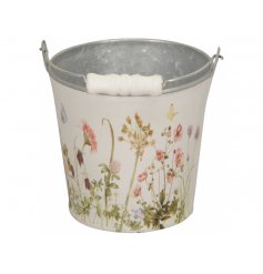 A rustic metal bucket with carry handle. Decorated with an enchanting display of wild flowers