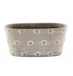 A chic stone planter with a rustic finish. A shabby chic item with a cute heart design. 