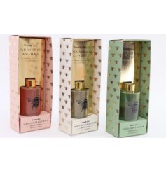 A mix of 3 pastel coloured scented reed diffusers, each with a luxurious summer bee motif. 