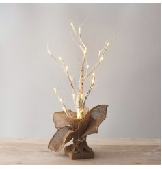 A table top sized birch twig tree with rustic jute sack base. 