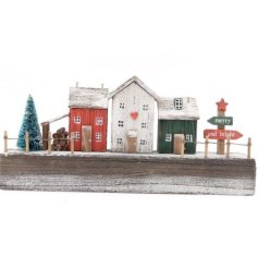This gorgeous Christmas ornament features a row of rustic houses in traditional festive colours, a log store and tree. 