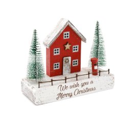 A charming wooden Christmas house with trees and a postbox. A unique interior accessory with a rustic finish. 