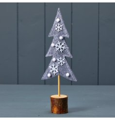 A gorgeous felt Christmas tree stood upon a natural wooden base. Decorated with wooden snowflakes and pom poms. 