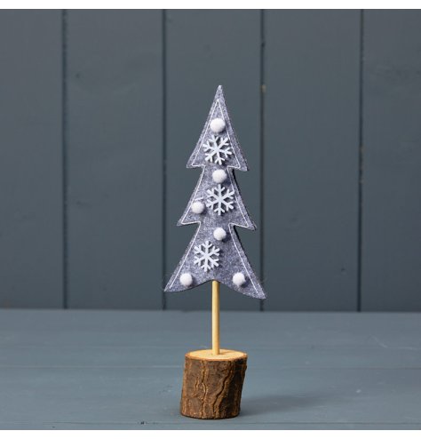 A beautiful felt Christmas tree decorated with snowflakes and pom poms. Set upon a natural wooden bark base. 