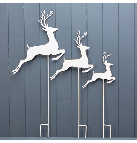 A set of 3 white metal dancing reindeer decorations for the garden. 