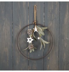 A rustic round metal wreath with an abundance of festive foliage and white wooden stars.