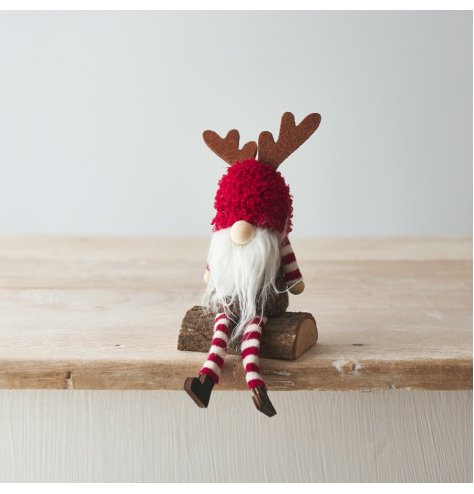 A gorgeous sitting gonk decoration with antlers. Sat upon a rustic wooden log.