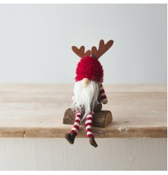 A unique sitting gonk decoration with red and white stripes and cute wooden antlers. Complete with rustic wooden log.
