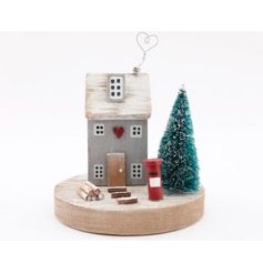 A festive decoration, featuring a grey wooden house
