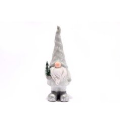 A charming ceramic gonk ornament, holding a green fir tree