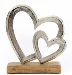 A chic home ornament featuring a large and small heart on a mango wood base. 