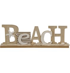 A chic 3D BEACH sign with coastal themed accents, including seashells and fishing net.