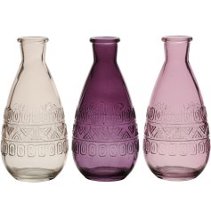 An assortment of 3 decorative glass vases in a mix of purple colours. 
