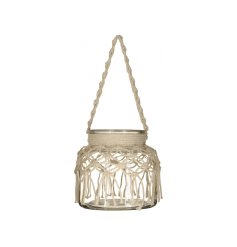 A boho chic hanging lantern with a beautiful macrame cover.